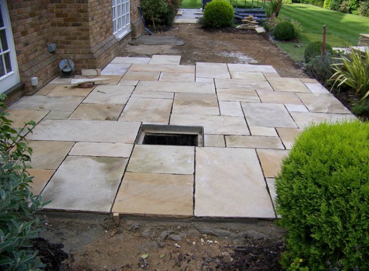 Fossil Mint Sandstone Paving in Cobham, Surrey - A rear terrace relaid using the original Fossil Mint Sandstone paving. Garden Paving - MDB Landscapes