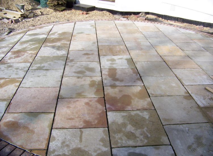 Kota Brown Limestone Paving in Fleet, Hampshire - A circular edged terrace area with adjacent timber decking. Garden Paving - MDB Landscapes