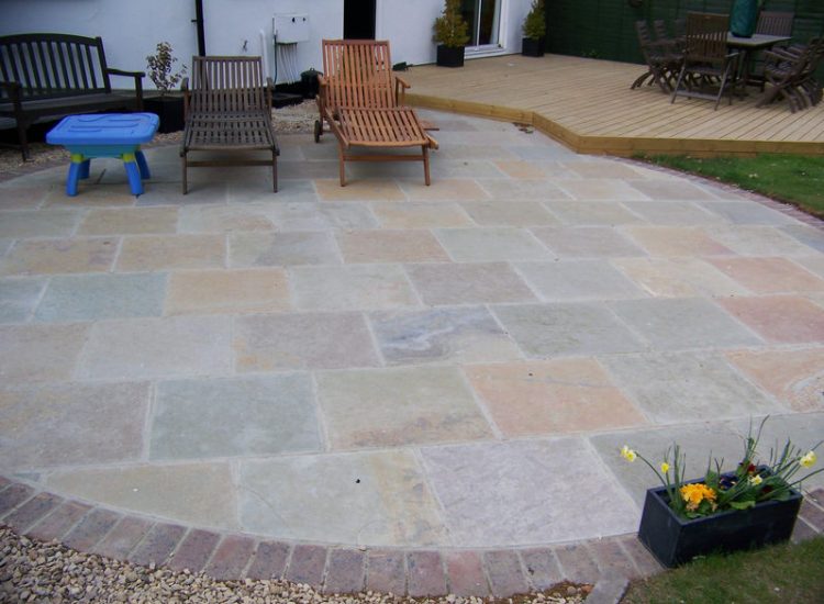 Kota Brown Limestone Paving in Fleet, Hampshire - A circular edged terrace area with adjacent timber decking. Garden Paving - MDB Landscapes