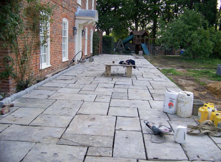 Reclaimed Yorkstone Paving in Dippenhall, Farnham, Surrey - A large rear terrace relaid using traditional reclaimed English Yorkstone. Garden Paving - MDB Landscapes