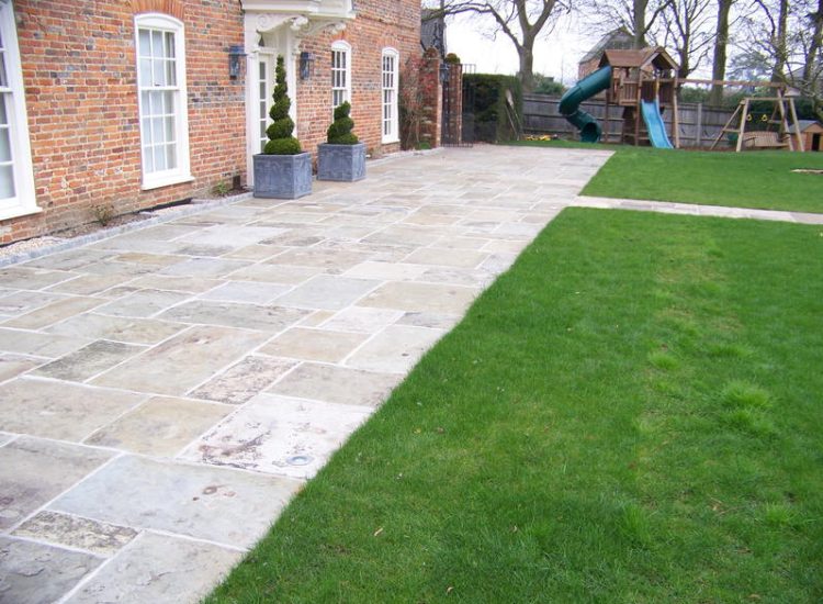 Reclaimed Yorkstone Paving in Dippenhall, Farnham, Surrey - A large rear terrace relaid using traditional reclaimed English Yorkstone. Garden Paving - MDB Landscapes