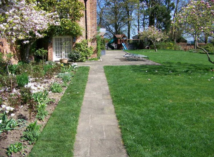 Reclaimed Yorkstone Paving in Dippenhall, Farnham, Surrey - A large rear terrace relaid using traditional reclaimed English Yorkstone. Garden Paving - MDB Landscapes