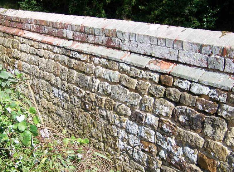 Repointing works in West Lavington, Midhurst, West Sussex - Repointing of an old dilapidated stone wall. Re-pointing works for Surrey and Hampshire - MDB Landscapes