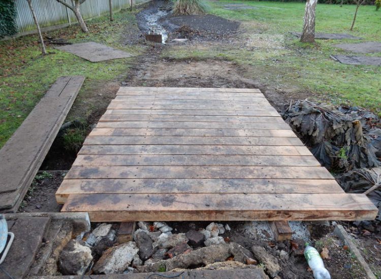 Garden Drainage and Brook Management Worplesdon, Guildford, Surrey - An existing brook had become over grown and blocked with vegetation and silt build up. Brook was cleared, re-ditched, a new under ground pipe installed, surrounding banks and lawns re-turfed and finally construction of a new Oak sleeper bridge to replace the old one. Garden Drainage - MDB Landscapes