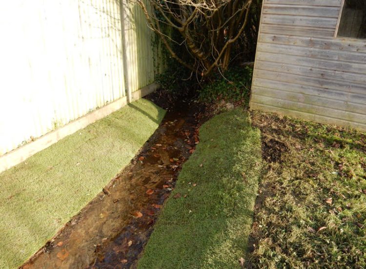 Garden Drainage and Brook Management Worplesdon, Guildford, Surrey - An existing brook had become over grown and blocked with vegetation and silt build up. Brook was cleared, re-ditched, a new under ground pipe installed, surrounding banks and lawns re-turfed and finally construction of a new Oak sleeper bridge to replace the old one. Garden Drainage - MDB Landscapes