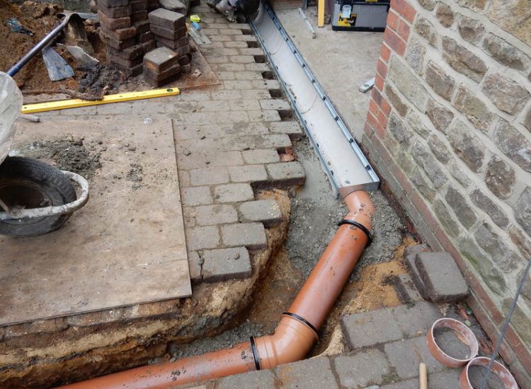 Driveway Drainage Farnham, Surrey - To help prevent further flooding of their garage the existing poor drainage infront of the garage was replaced with wide cast iron grated linear drainage channels. Garden Drainage - MDB Landscapes
