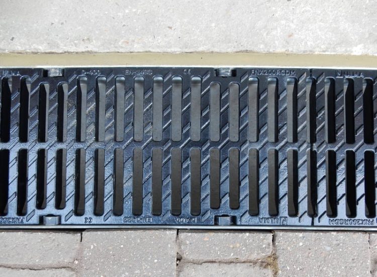 Driveway Drainage Farnham, Surrey - To help prevent further flooding of their garage the existing poor drainage infront of the garage was replaced with wide cast iron grated linear drainage channels. Garden Drainage - MDB Landscapes