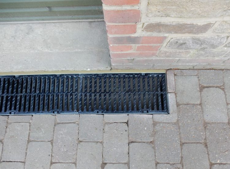Driveway Drainage Farnham, Surrey - To help prevent further flooding of their garage the existing poor drainage infront of the garage was replaced with wide cast iron grated linear drainage channels. Garden Drainage - MDB Landscapes