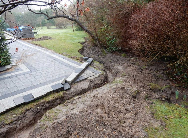 Driveway Drainage Ottershaw, Surrey - Linear drainage with cast iron gratings were proposed here to help prevent the constant threat of flooding from run off from the road. Water was diverted through large diamater pipe work and land drainage finaly being dispersed at the bottom of the garden. Garden Drainage - MDB Landscapes