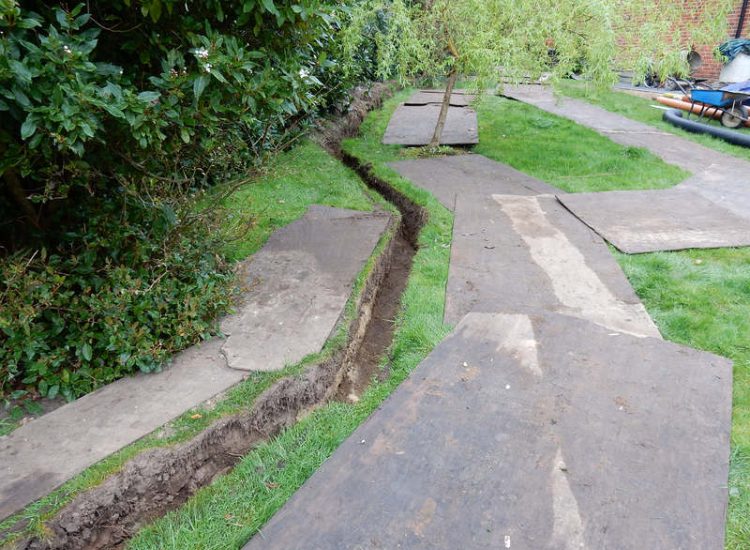 Driveway Drainage Ottershaw, Surrey - Linear drainage with cast iron gratings were proposed here to help prevent the constant threat of flooding from run off from the road. Water was diverted through large diamater pipe work and land drainage finaly being dispersed at the bottom of the garden. Garden Drainage - MDB Landscapes