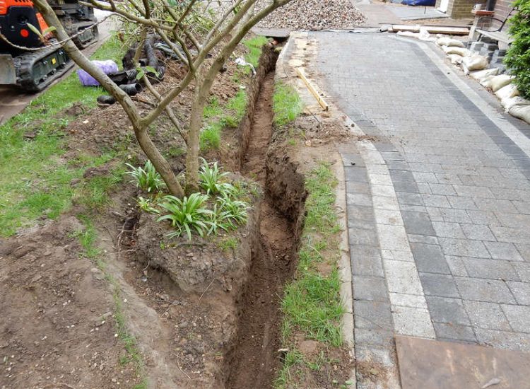 Driveway Drainage Ottershaw, Surrey - Linear drainage with cast iron gratings were proposed here to help prevent the constant threat of flooding from run off from the road. Water was diverted through large diamater pipe work and land drainage finaly being dispersed at the bottom of the garden. Garden Drainage - MDB Landscapes