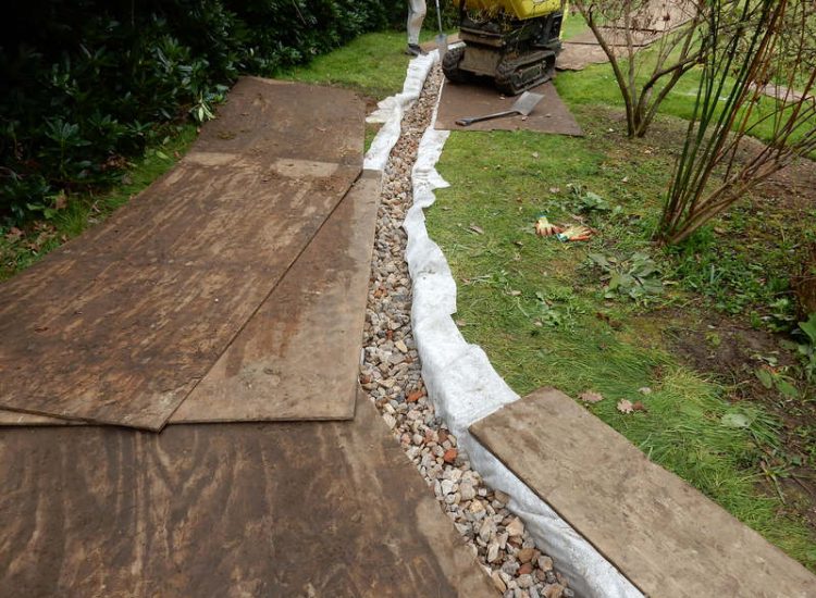 Driveway Drainage Ottershaw, Surrey - Linear drainage with cast iron gratings were proposed here to help prevent the constant threat of flooding from run off from the road. Water was diverted through large diamater pipe work and land drainage finaly being dispersed at the bottom of the garden. Garden Drainage - MDB Landscapes