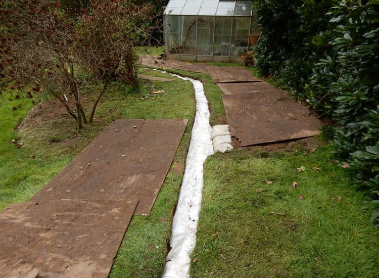 Driveway Drainage Ottershaw, Surrey - Linear drainage with cast iron gratings were proposed here to help prevent the constant threat of flooding from run off from the road. Water was diverted through large diamater pipe work and land drainage finaly being dispersed at the bottom of the garden. Garden Drainage - MDB Landscapes