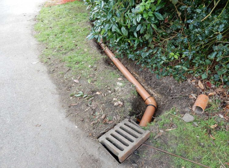 Driveway Drainage Ottershaw, Surrey - Linear drainage with cast iron gratings were proposed here to help prevent the constant threat of flooding from run off from the road. Water was diverted through large diamater pipe work and land drainage finaly being dispersed at the bottom of the garden. Garden Drainage - MDB Landscapes