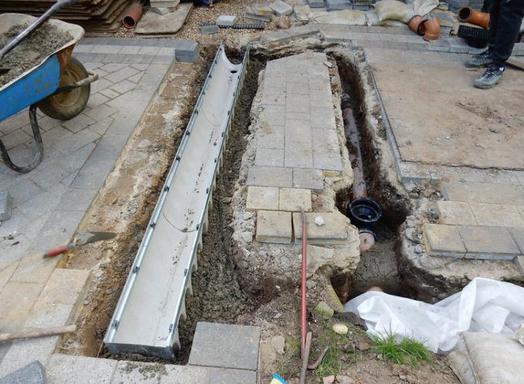 Driveway Drainage Ottershaw, Surrey - Linear drainage with cast iron gratings were proposed here to help prevent the constant threat of flooding from run off from the road. Water was diverted through large diamater pipe work and land drainage finaly being dispersed at the bottom of the garden. Garden Drainage - MDB Landscapes