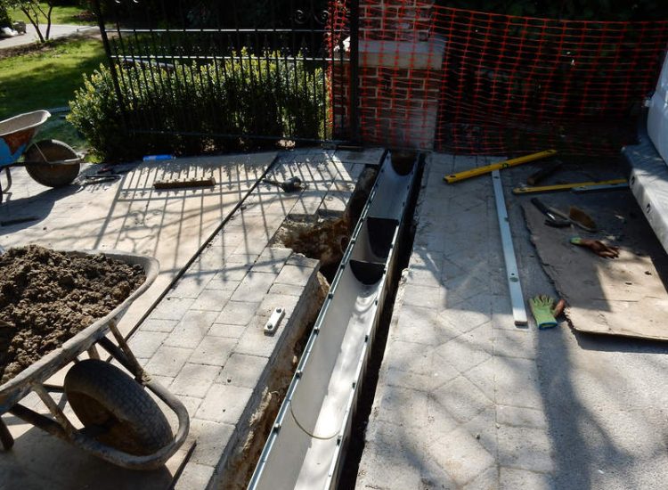 Driveway Drainage Ottershaw, Surrey - Linear drainage with cast iron gratings were proposed here to help prevent the constant threat of flooding from run off from the road. Water was diverted through large diamater pipe work and land drainage finaly being dispersed at the bottom of the garden. Garden Drainage - MDB Landscapes