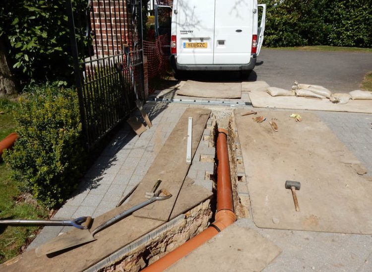 Driveway Drainage Ottershaw, Surrey - Linear drainage with cast iron gratings were proposed here to help prevent the constant threat of flooding from run off from the road. Water was diverted through large diamater pipe work and land drainage finaly being dispersed at the bottom of the garden. Garden Drainage - MDB Landscapes