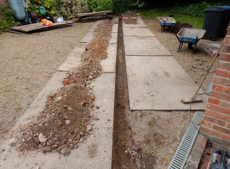 Garden Drainage Farnham, Surrey - Trapped water behind retaining walls was constantly seeping through flooding areas around the house. The most cost effective solution for the client was to catch the flow of water house side of retaining wall and divert it into a brook. Garden Drainage -MDB Landscapes