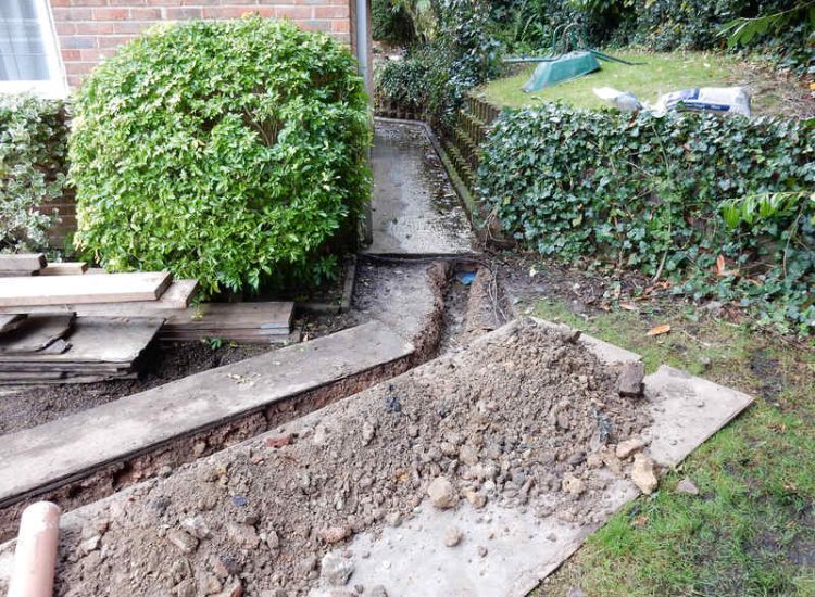 Garden Drainage Farnham, Surrey - Trapped water behind retaining walls was constantly seeping through flooding areas around the house. The most cost effective solution for the client was to catch the flow of water house side of retaining wall and divert it into a brook. Garden Drainage -MDB Landscapes