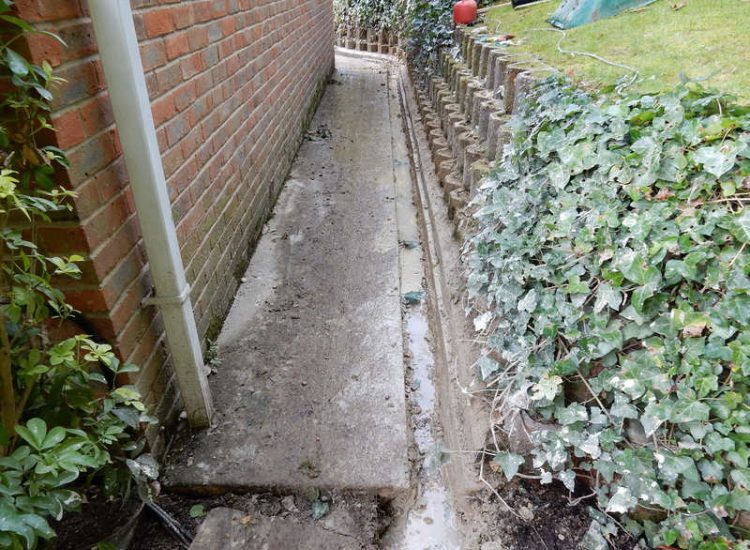 Garden Drainage Farnham, Surrey - Trapped water behind retaining walls was constantly seeping through flooding areas around the house. The most cost effective solution for the client was to catch the flow of water house side of retaining wall and divert it into a brook. Garden Drainage -MDB Landscapes