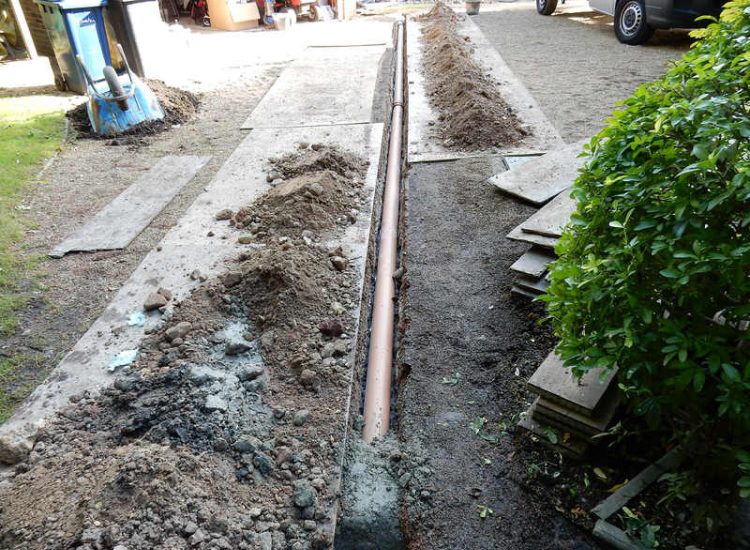 Garden Drainage Farnham, Surrey - Trapped water behind retaining walls was constantly seeping through flooding areas around the house. The most cost effective solution for the client was to catch the flow of water house side of retaining wall and divert it into a brook. Garden Drainage -MDB Landscapes