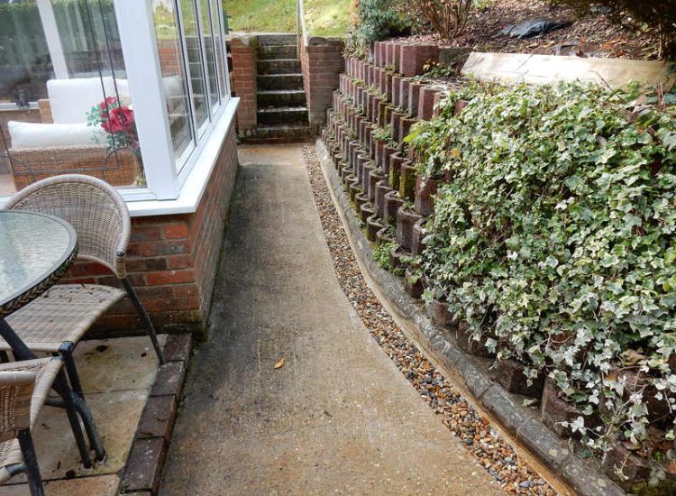 Garden Drainage Farnham, Surrey - Trapped water behind retaining walls was constantly seeping through flooding areas around the house. The most cost effective solution for the client was to catch the flow of water house side of retaining wall and divert it into a brook. Garden Drainage -MDB Landscapes