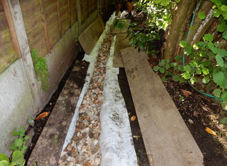 Garden Drainage Farnham, Surrey - A constant flow of in ground and over ground water was diverted to an existing culvert within the rear garden. Garden Drainage - MDB Landscapes