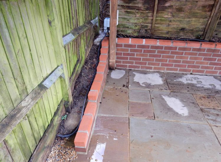 Garden Drainage Lovedean, Hampshire - The installation by the client of a small retained terrace area restricted and diverted the natural flow of water running through the rear garden. The now trapped water was diverted via a new sump and pump and finally discharging into a storm water drain. Garden Drainage - MDB Landscapes