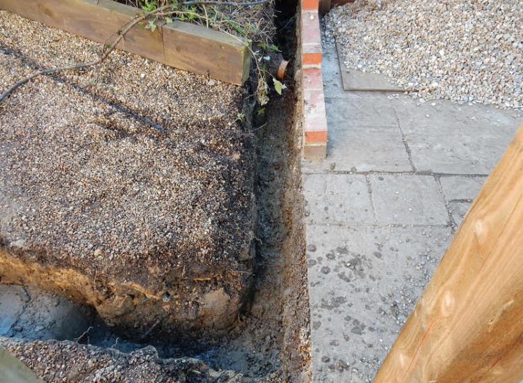 Garden Drainage Lovedean, Hampshire - The installation by the client of a small retained terrace area restricted and diverted the natural flow of water running through the rear garden. The now trapped water was diverted via a new sump and pump and finally discharging into a storm water drain. Garden Drainage - MDB Landscapes