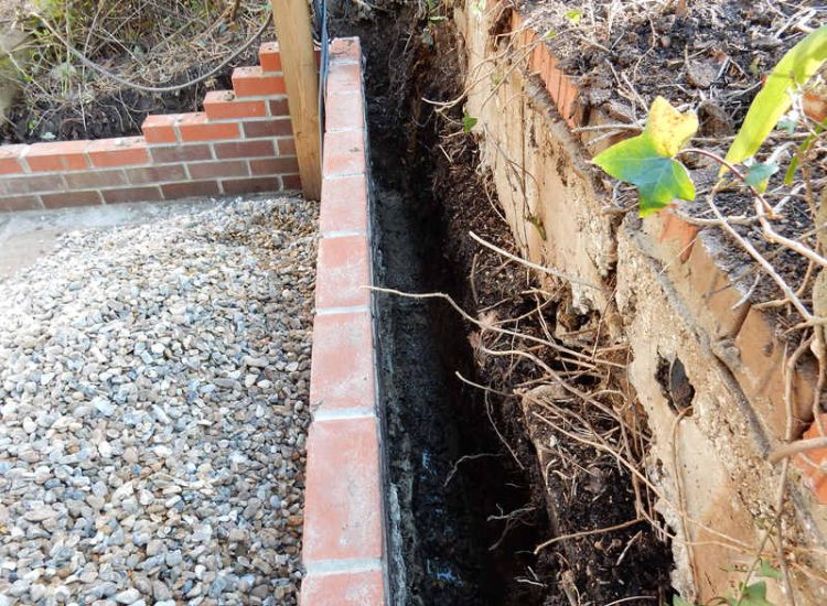 Garden Drainage Lovedean, Hampshire - The installation by the client of a small retained terrace area restricted and diverted the natural flow of water running through the rear garden. The now trapped water was diverted via a new sump and pump and finally discharging into a storm water drain. Garden Drainage - MDB Landscapes