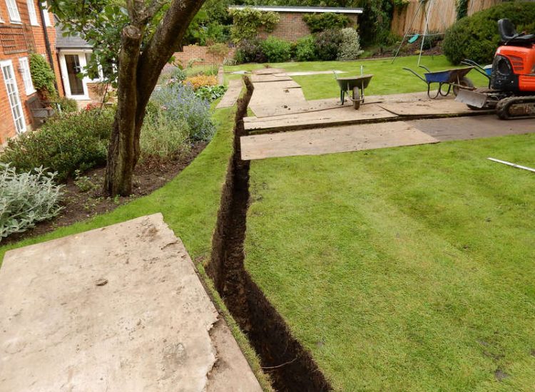 Lawn Drainage Crondall, Hampshire - A substantial lawn area suffering from water ingress from highr ground. Land drainage was installed with drainage trenches re-turfed. The outlet point here was lower ground within a wooded area. Garden Drainage - MDB Landscapes