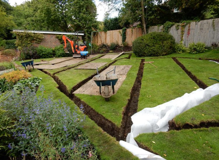 Lawn Drainage Crondall, Hampshire - A substantial lawn area suffering from water ingress from highr ground. Land drainage was installed with drainage trenches re-turfed. The outlet point here was lower ground within a wooded area. Garden Drainage - MDB Landscapes