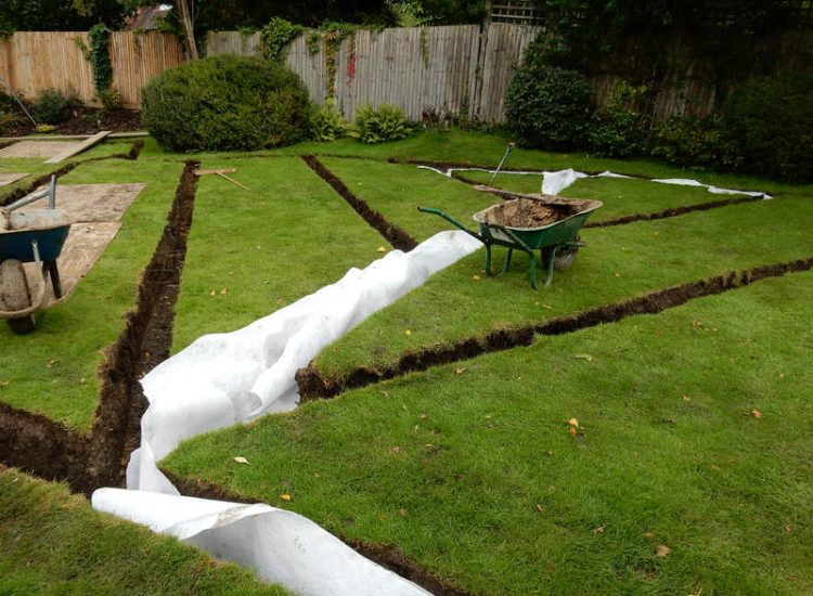 Lawn Drainage Crondall, Hampshire - A substantial lawn area suffering from water ingress from highr ground. Land drainage was installed with drainage trenches re-turfed. The outlet point here was lower ground within a wooded area. Garden Drainage - MDB Landscapes