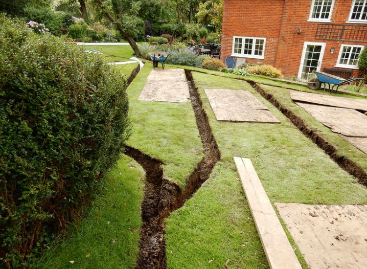 Lawn Drainage Crondall, Hampshire - A substantial lawn area suffering from water ingress from highr ground. Land drainage was installed with drainage trenches re-turfed. The outlet point here was lower ground within a wooded area. Garden Drainage - MDB Landscapes