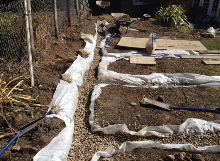 Garden and Lawn Drainage Farnham, Surrey - Drainage was proposed and installed to help capture and divert existing run off from a running brook causing issues with wet and boggy lawn areas. The water was dispersed via newly replaced drainage gullies connected to an existing outlet. Garden Drainage - MDB Landscapes