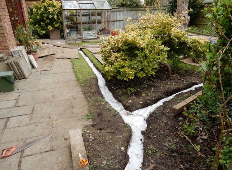 Garden Drainage Great Bookham, Leatherhead, Surrey - An ongoing issue with excessive water finding its way into the cellar of this clients property puting pressure on already installed sump pumps. Perimeter drainage was installed to catch and divert the flow of water helping to reduce the required constant use of the installed pumps. Garden Drainage - MDB Landscapes