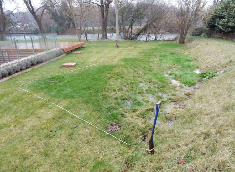 Lawn Drainage Hersham, Surrey - Building works had left an area of the garden in poor state, compacted with buried waste materials. There was also an added issue of Constant water ingress from an unknown source. Levels were reduced first, drainage installed using the river as an outlet source, topsoil spread and grass seeded on completion. Garden Drainage - MDB Landscapes