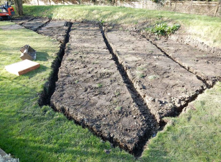 Lawn Drainage Hersham, Surrey - Building works had left an area of the garden in poor state, compacted with buried waste materials. There was also an added issue of Constant water ingress from an unknown source. Levels were reduced first, drainage installed using the river as an outlet source, topsoil spread and grass seeded on completion. Garden Drainage - MDB Landscapes