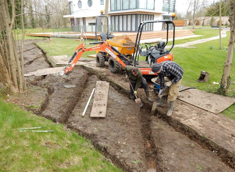 Lawn Drainage Hersham, Surrey - Building works had left an area of the garden in poor state, compacted with buried waste materials. There was also an added issue of Constant water ingress from an unknown source. Levels were reduced first, drainage installed using the river as an outlet source, topsoil spread and grass seeded on completion. Garden Drainage - MDB Landscapes