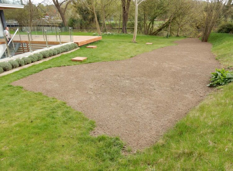 Lawn Drainage Hersham, Surrey - Building works had left an area of the garden in poor state, compacted with buried waste materials. There was also an added issue of Constant water ingress from an unknown source. Levels were reduced first, drainage installed using the river as an outlet source, topsoil spread and grass seeded on completion. Garden Drainage - MDB Landscapes