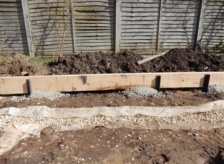 Garden Drainage and New High Specification Lawn Guildford, Surrey - To achieve the requirement of a new lawn extensive drainage was installed via the use of a sump and pump, lawn area was raised with Oak sleeper edging and finally a new lawn laid upon a high end rootzone medium. Garden drainage - MDB Landscapes