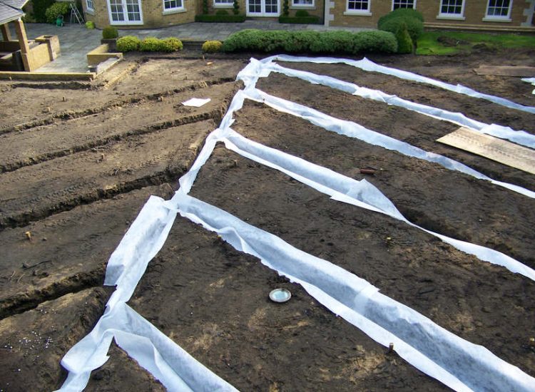 Lawn Drainage Cobham, Surrey - A poor soil medium for both front and rear gardens left lawn areas very water logged and difficult to manage. Extensive land drainage was installed, new rootzone medium imported in and lawns re-turfed. Garden Drainage - MDB Landscapes