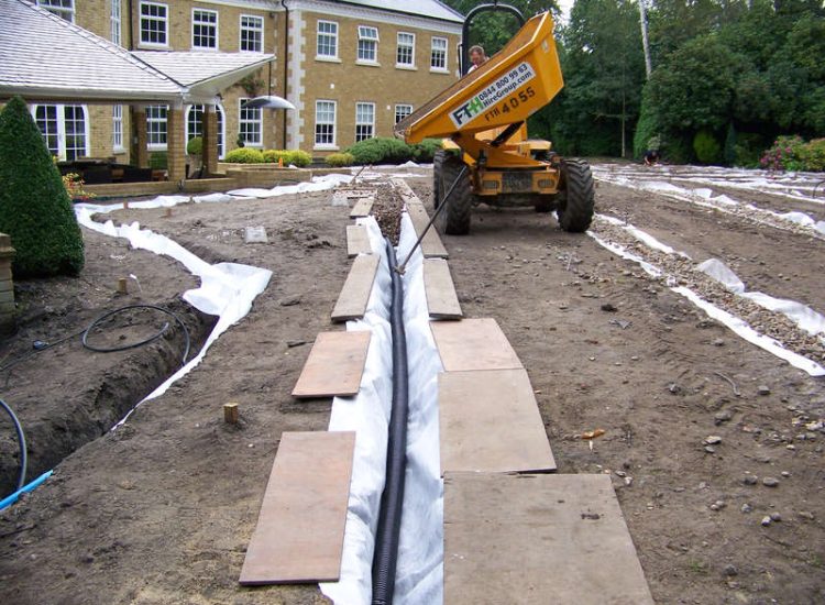 Lawn Drainage Cobham, Surrey - A poor soil medium for both front and rear gardens left lawn areas very water logged and difficult to manage. Extensive land drainage was installed, new rootzone medium imported in and lawns re-turfed. Garden Drainage - MDB Landscapes