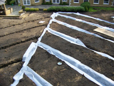 Lawn Construction in Oxshott, Surrey - Large areas of garden lawns struggling with drainage issues. Areas reduced in levels first, land drainage installed followed by the importaion of rootzone and completed areas re-turfed. Lawns & Turfing - MDB Landscapes