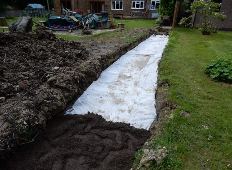 Planting Border Drainage Cranleigh, Surrey - To aid reinstatement of a new boundary hedge a bold drainage solution was required incorporating drainage layers, land drains and the use of a sump and pump. Garden drainage - MDB Landscapes