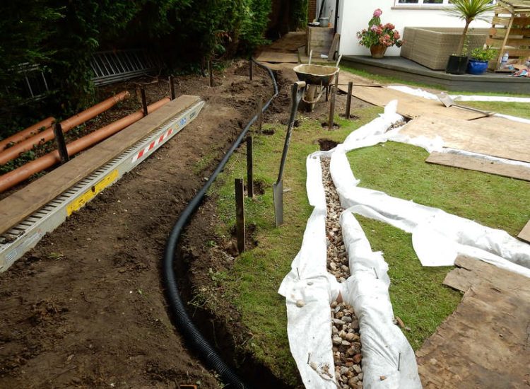Garden and Lawn Drainage Esher, Surrey - Land drainage was installed here leading to a sump and pump to help with the issues of the clay soil type lawn. Other works included hardwood sleeper raised planting borders and driveway drainage. Garden drainage - MDB Landscapes