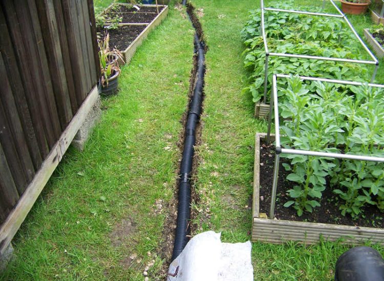 Lawn Drainage Wrecclesham, Farnham, Surrey - A constant in ground flow of water and poor water retentive soil type left the majority of this rear lawn wet and boggy. Extensive land drains were proposed and installed to great effect. The lower area of the garden was used as a discharge point for the drained water collecting first into a water reservoir. Garden Drainage - MDB Landscapes