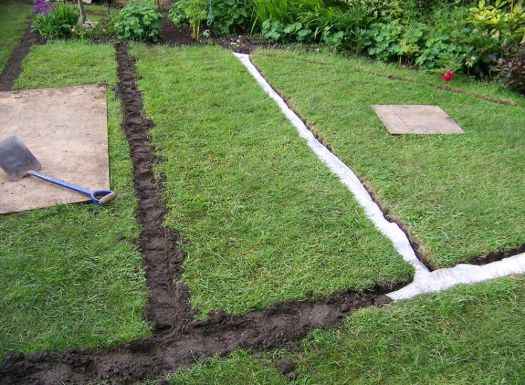 Lawn Drainage Wrecclesham, Farnham, Surrey - A constant in ground flow of water and poor water retentive soil type left the majority of this rear lawn wet and boggy. Extensive land drains were proposed and installed to great effect. The lower area of the garden was used as a discharge point for the drained water collecting first into a water reservoir. Garden Drainage - MDB Landscapes